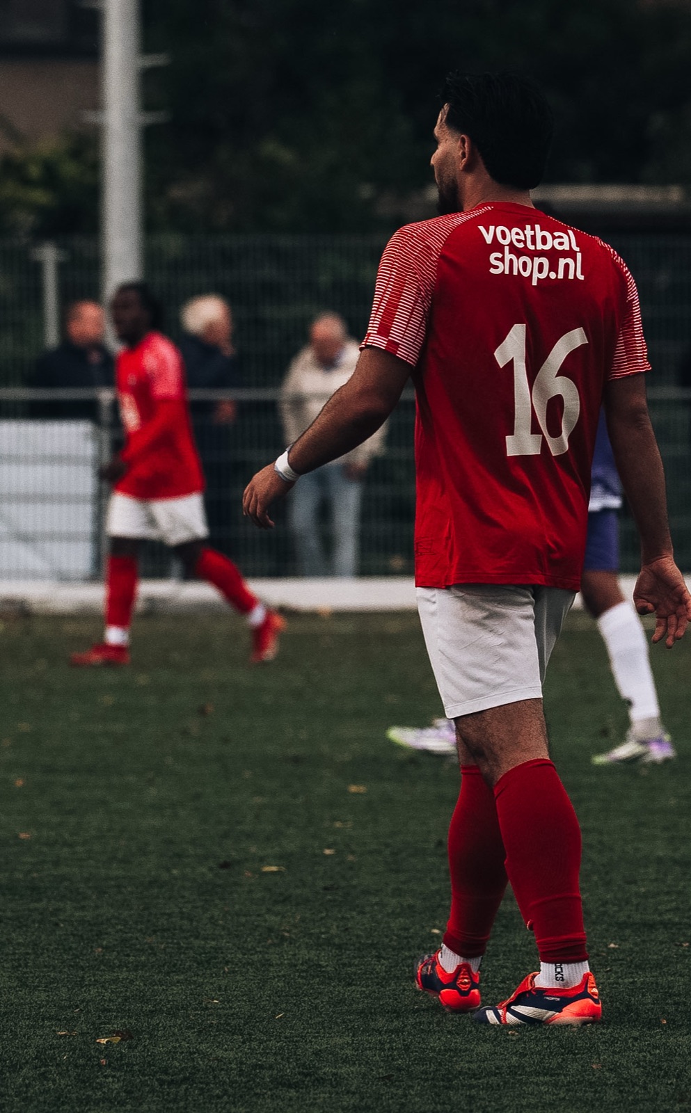 Speler met rugnummer 16 in rood shirt
